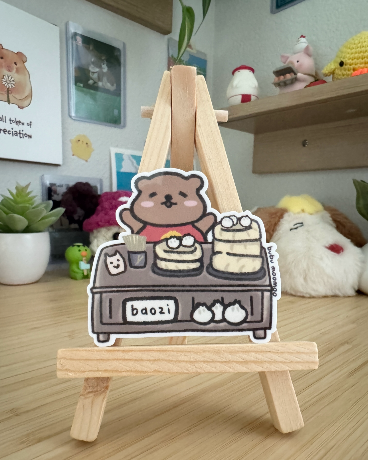 Small wooden easel with a cartoon character sticker of a bear on a wooden desk.
